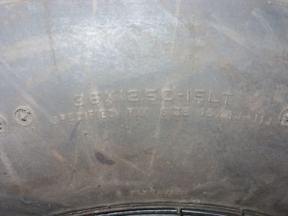 Close-up of a tire showing size 33x12.50-15LT and specified rim size 15x8J-11J.