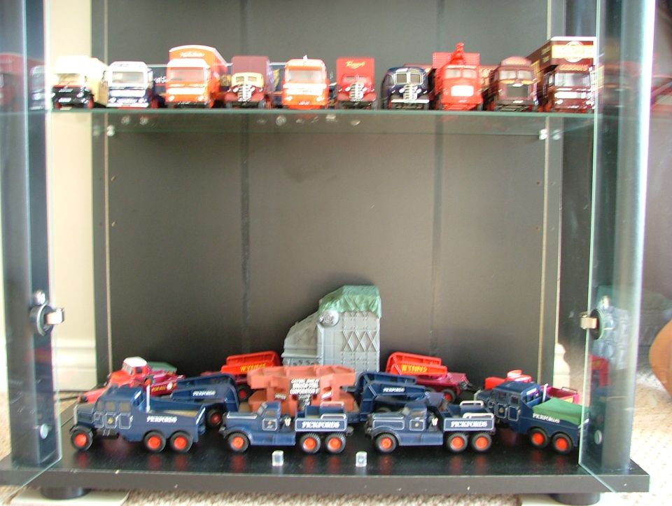 Display cabinet of die-cast Pickfords and Wynns model trucks on two shelves