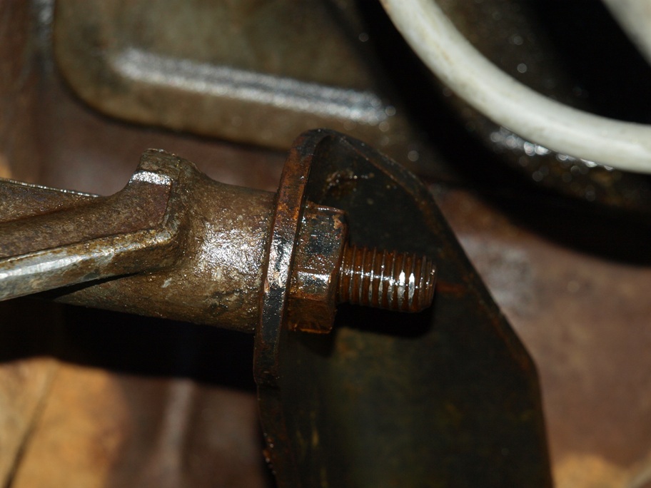 Close-up of a rusty metal bracket with a bolt and nut.