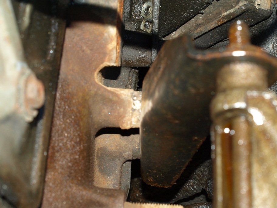 Close-up of rusty engine parts, showing a curved metal piece and textured metal.