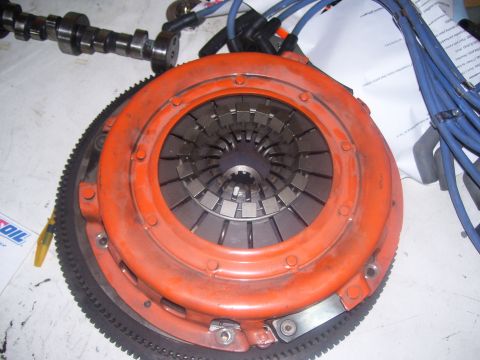 1990 Ford Mustang - A close-up view of a clutch assembly and flywheel, likely for a performance vehicle. The clutch pressure plate is bright orange, and the fl…