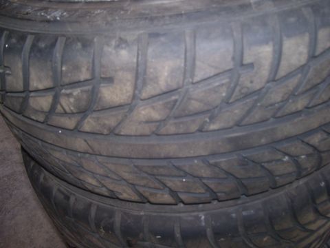 1990 Ford Mustang - A close-up view shows the tread pattern of two stacked tires. The tires are black and appear to be worn.