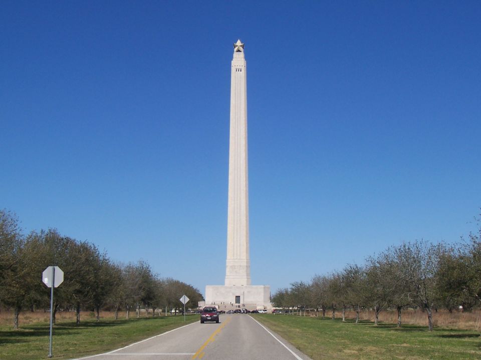 Tall stone monument with a star at the top viewed from a road