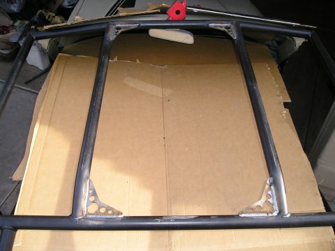 1986 Toyota Hilux - A custom roll cage, likely for a Toyota Hilux, is shown installed over a large piece of cardboard. The cage is constructed from black metal…