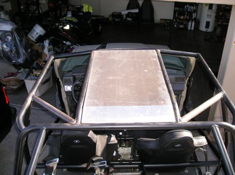 1986 Toyota Hilux - Overhead view of a custom roll cage built around the interior of a vehicle, showing two racing seats and a metal panel covering the roof ar…