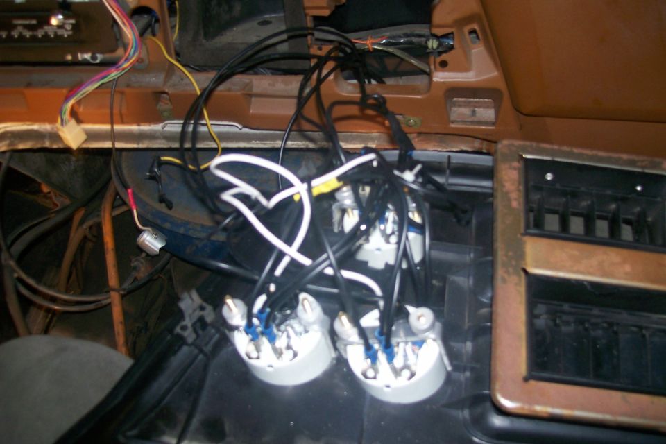 Close-up of car dashboard showing wiring and gauges.