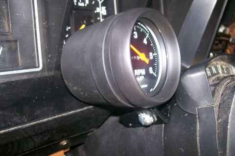 1982 Ford E350 - A close-up interior shot shows a tachometer gauge mounted on the dashboard of a vehicle. The gauge has a yellow needle pointing to approxim…