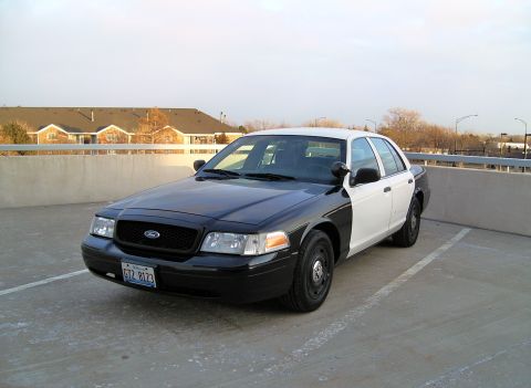 2004 Ford Crown Victoria - This 2004 Ford Crown Victoria is shown in a two-tone black and white paint scheme from a front three-quarter perspective.