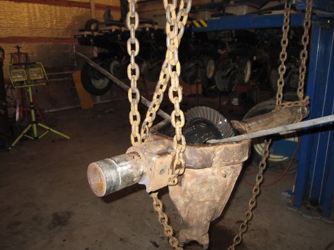 1992 Ford Bronco - A differential housing with gears is suspended by chains, ready for repair or inspection in a garage setting.