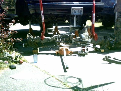 1995 Ford Bronco - The rear suspension of a 1995 Ford Bronco is undergoing maintenance, supported by jack stands, with its license plate clearly visible.