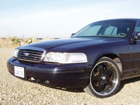 2001 Ford Crown Victoria - Front quarter view of a dark purple 2001 Ford Crown Victoria, custom black wheels and a chrome grille.