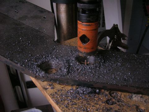 1996 Ford Bronco - Metal plate being drilled with a hole saw, creating metal shavings. Drill press equipment is visible.