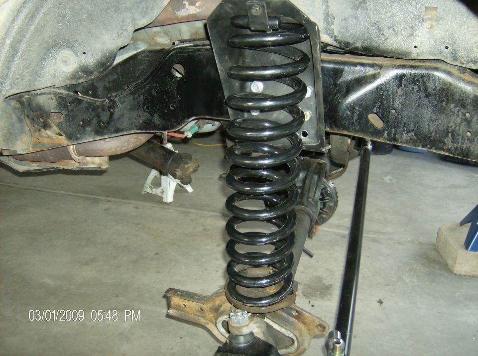 Front suspension part with large coil spring and chassis components