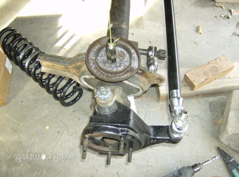 1990 Ford Bronco - Close-up of a vehicle's front axle suspension components, including a coil spring and shock mount.