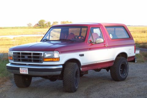 1995 Ford Bronco - This two-tone red and white 1995 Ford Bronco is shown from a 3/4 front angle.