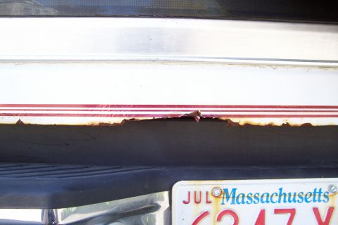 1995 Ford Bronco - Significant rust damage is visible along the lower body panel of the vehicle, beneath a pinstripe detail.