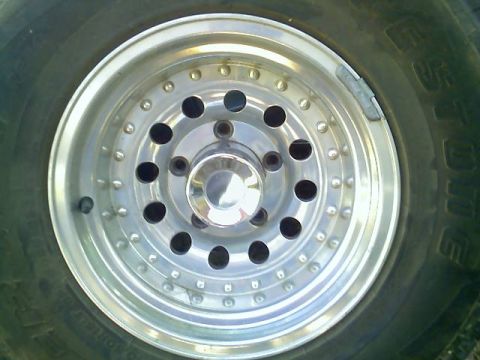 1996 Ford Bronco - A close-up shot focuses on a vehicle's alloy wheel and tire, showing details of the rim and tread.
