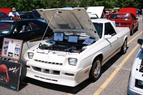1976 Ford Ranchero - A white coupe utility is displayed with its hood open, revealing the engine and informational signs.