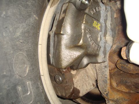 1978 Chevrolet C/K Pickup - A close-up view of a vehicle's brake caliper, showing stamped part numbers and markings.