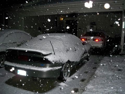1995 Ford Probe - Cars parked outside during a snowfall at night.