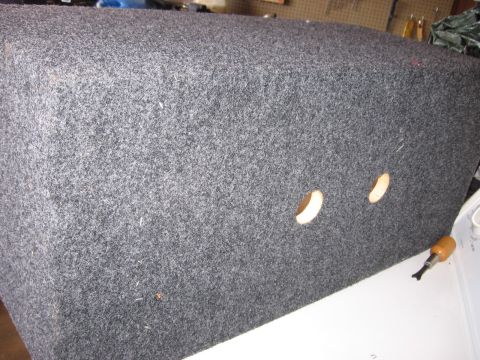1980 Jeep CJ7 - A carpeted speaker box with two circular openings is shown, with a screwdriver on the right.