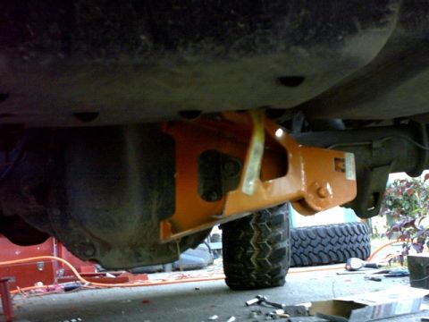 1995 Ford Bronco - Underside view of a vehicle's suspension system with an orange component and tire.