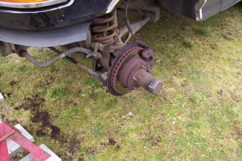 1995 Ford Bronco - Close-up view of a vehicle's front wheel hub and suspension system, showing mechanical components.