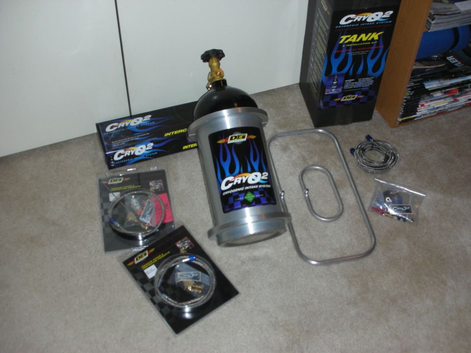 CryO2 cryogenic intake system kit with CO2 tank, hoses, bracket, and fittings on carpet.