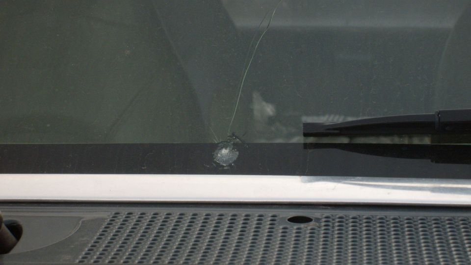 Cracked windshield chip with crack extending upward near wiper