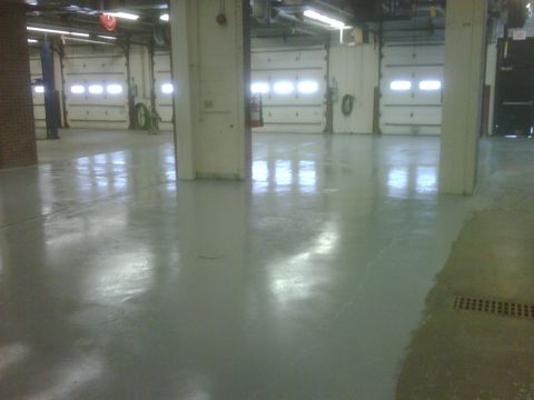 1996 Ford Bronco - Photograph of an empty shop garage interior with reflective epoxy floor and bay doors.