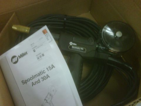 1996 Ford Bronco - Photograph of a Miller Spoolmatic spool gun and its manual booklet in an open shipping box.