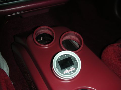 1992 Ford Crown Victoria - A digital gauge is installed in the center console of a car, between two cup holders. The gauge has a silver bezel and a black screen displ…