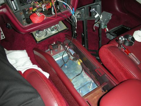 1992 Ford Crown Victoria - The interior of a vehicle shows a disassembled center console with various wires and electronic components exposed. Tools and wiring suppli…