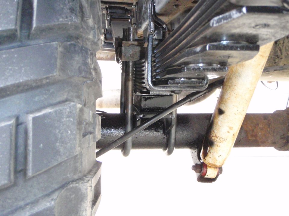 Rear suspension of a 1996 Ford Bronco with leaf springs, U-bolts, and shock absorber.