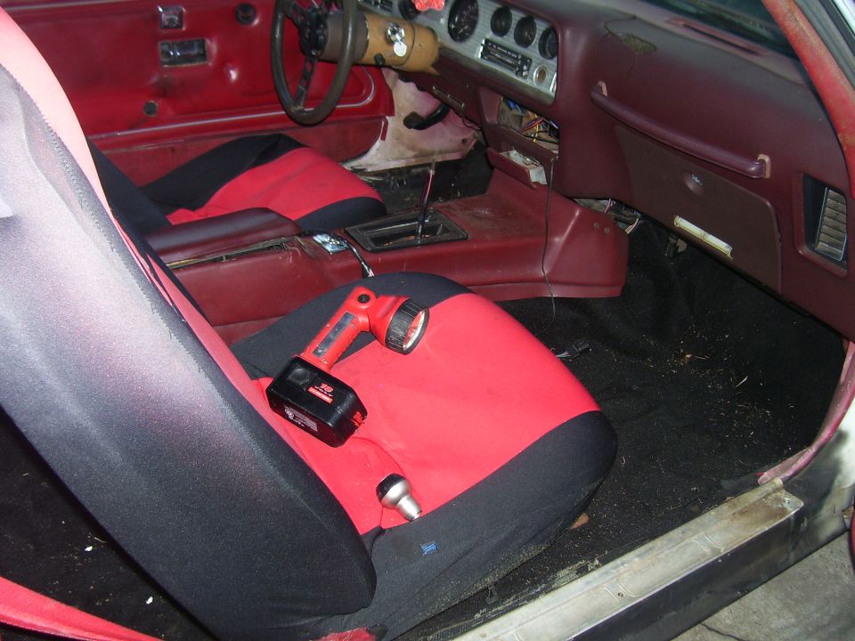 Car interior showing red seats and floor mats. Keys are on a red mat