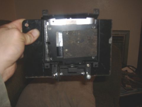 1997 Ford Crown Victoria - A black car part is held by a hand, with a Supermotors.net logo visible at the bottom right.