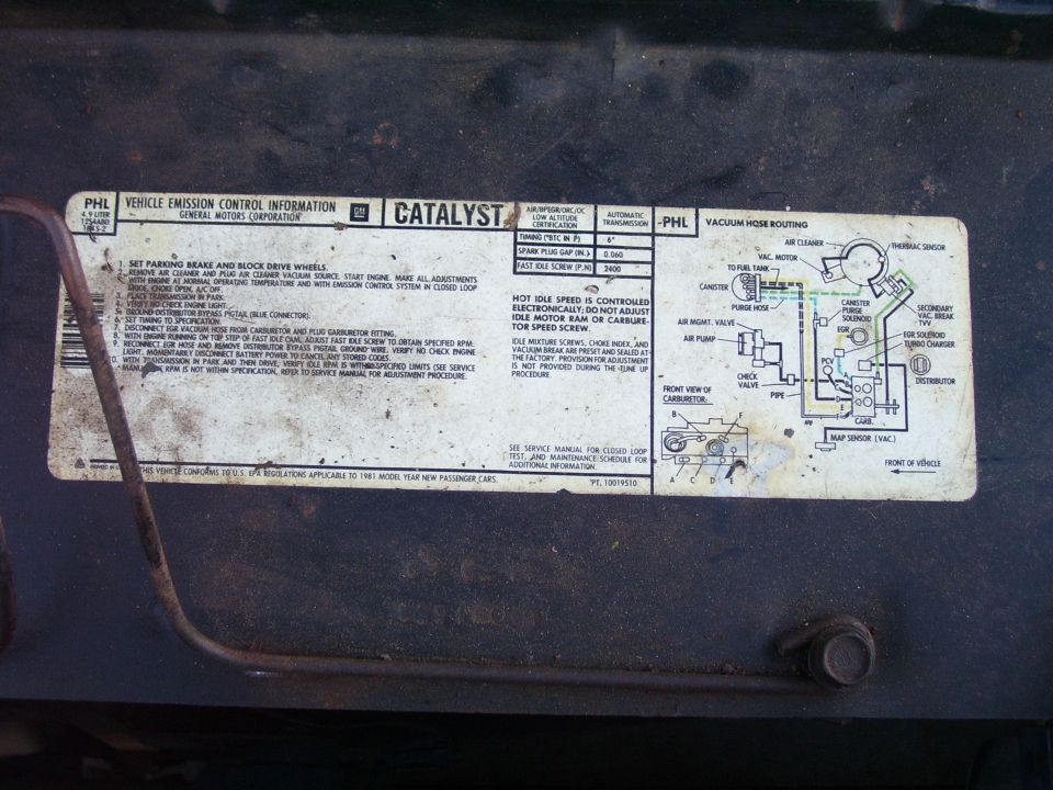 Vehicle emissions control information decal on underside of hood.