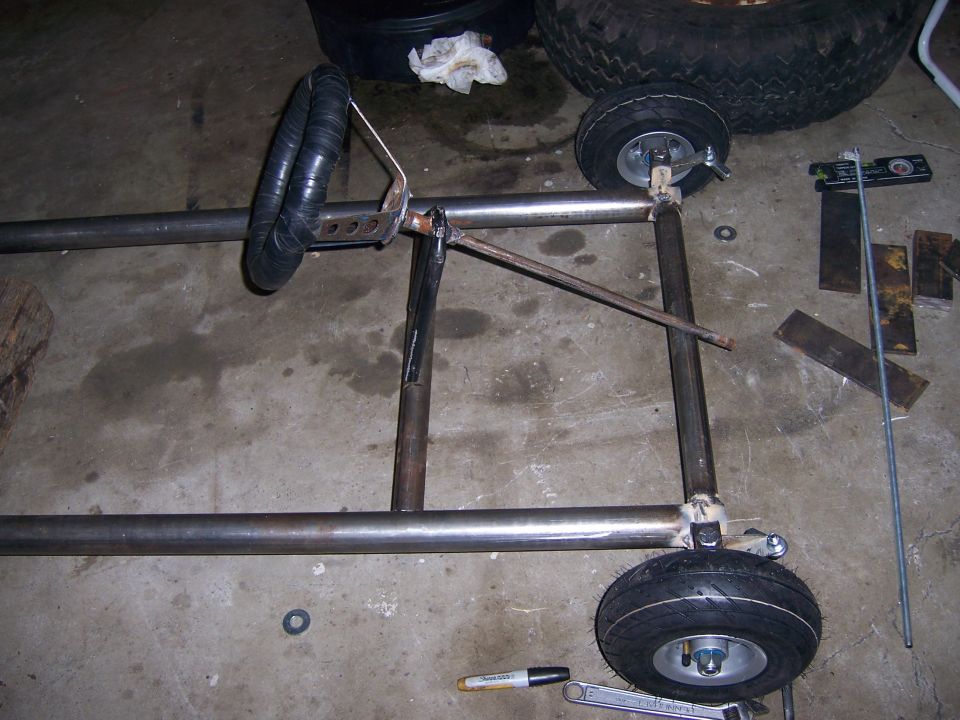 Photo of a partially built tubular steel go-kart frame on a garage floor