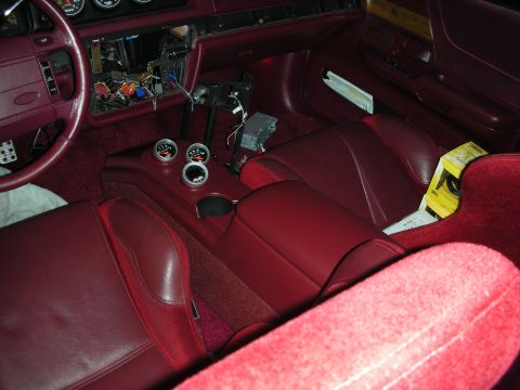 1992 Ford Crown Victoria - The interior of a car with red leather seats and carpet is shown, featuring a custom center console with three gauges and a steering wheel…