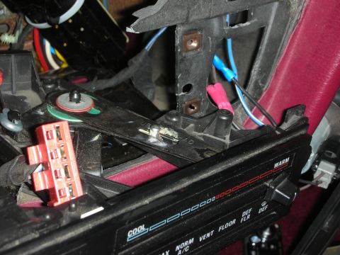 1992 Ford Crown Victoria - A close-up view of the interior of a vehicle, showing wiring, a red connector, and part of the climate control panel with labels for "COOL"…