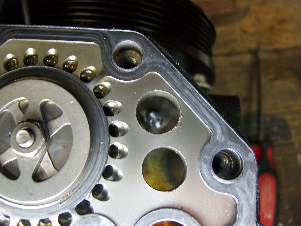 Close-up photo of a water pump impeller, bolt holes and pulley