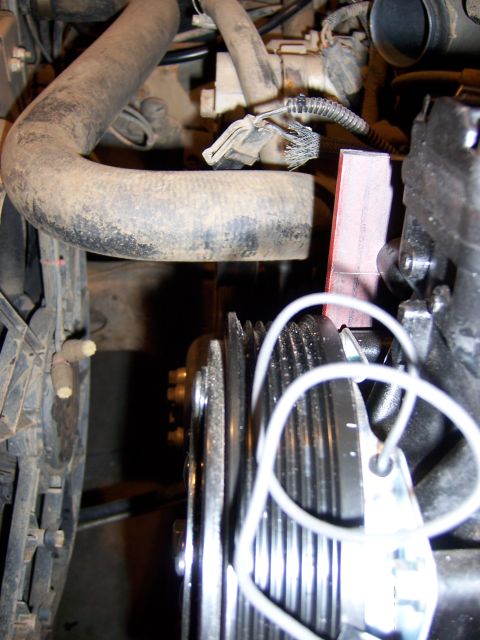 1991 Ford Bronco - Close-up view of engine components, including pulleys and hoses, with attached tags.