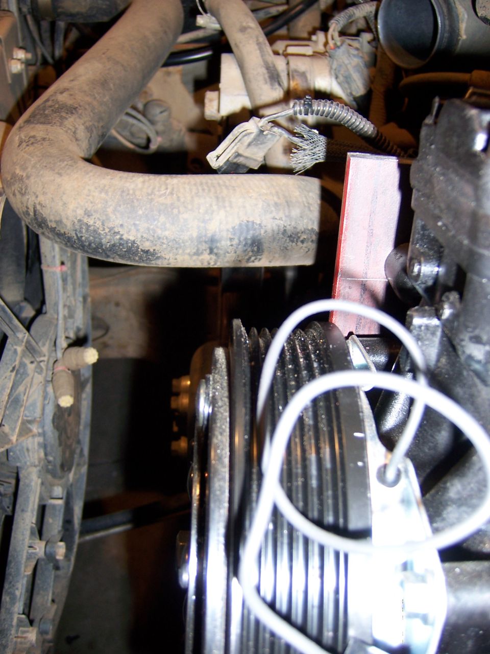 Engine pulleys and hoses with a red marker and white tag