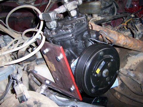 1991 Ford Bronco - Close-up view of an air conditioning compressor assembly, likely part of an engine repair or upgrade.