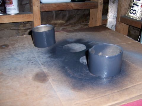 1991 Ford Bronco - Two metal cylinders have been painted gray and are drying on a cardboard surface.