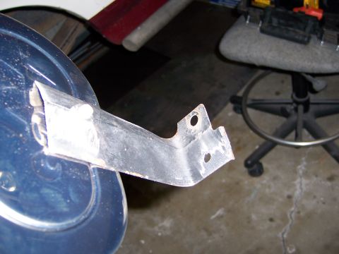 1991 Ford Bronco - A metal bracket is affixed to a blue cylindrical object, with a workshop chair visible behind it the background.
