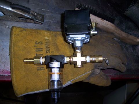 1991 Ford Bronco - Air compressor pressure switch and filter assembly mounted on a work glove.