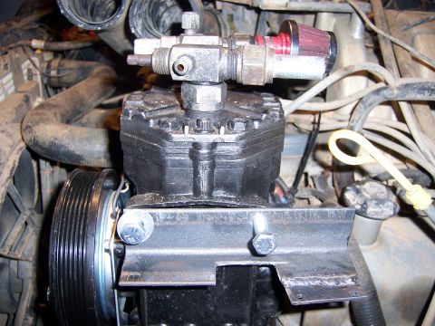 1991 Ford Bronco - This is a close-up view of a vehicle's engine, focusing on a component with attached hoses and a small air filter.