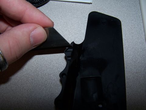 1986 Ford Bronco - A hand uses a utility knife to modify a black plastic part, with a Supermotors logo in the corner.