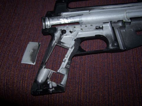 1986 Ford Bronco - Disassembled gun receiver and magazine shown on a textured surface.